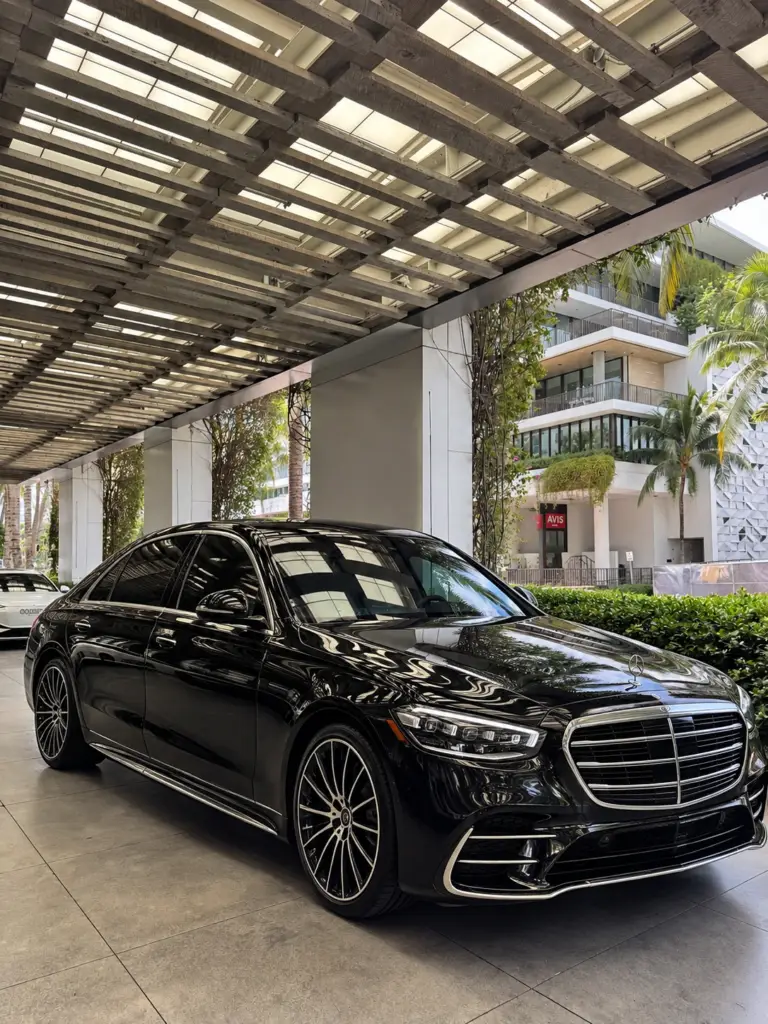 Black Mercedes-Benz S-Class S500 sedan at a Miami hotel entrance
